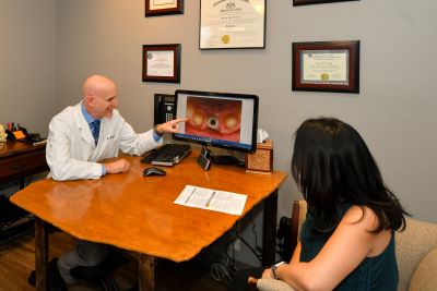Dr. Steinberg in his office explaining an image to a patient for holistic dentistry