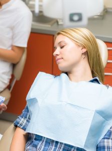 Woman asleep in a dental chair from dental sedation